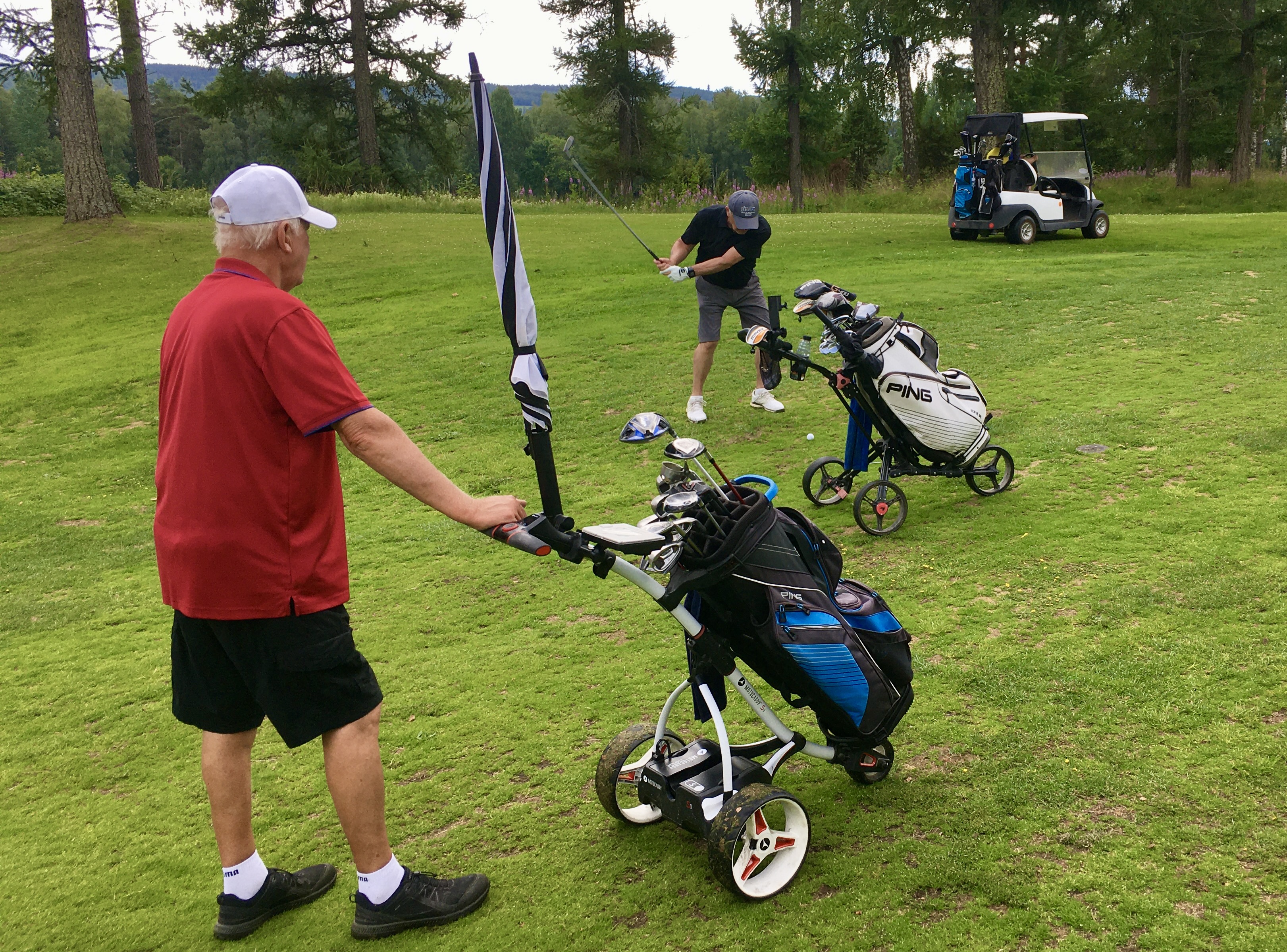 Lennart "Lelle" Karlsson på väg att slå till golfbollen på hål 16 under överinseende av medspelaren Åke Nalén