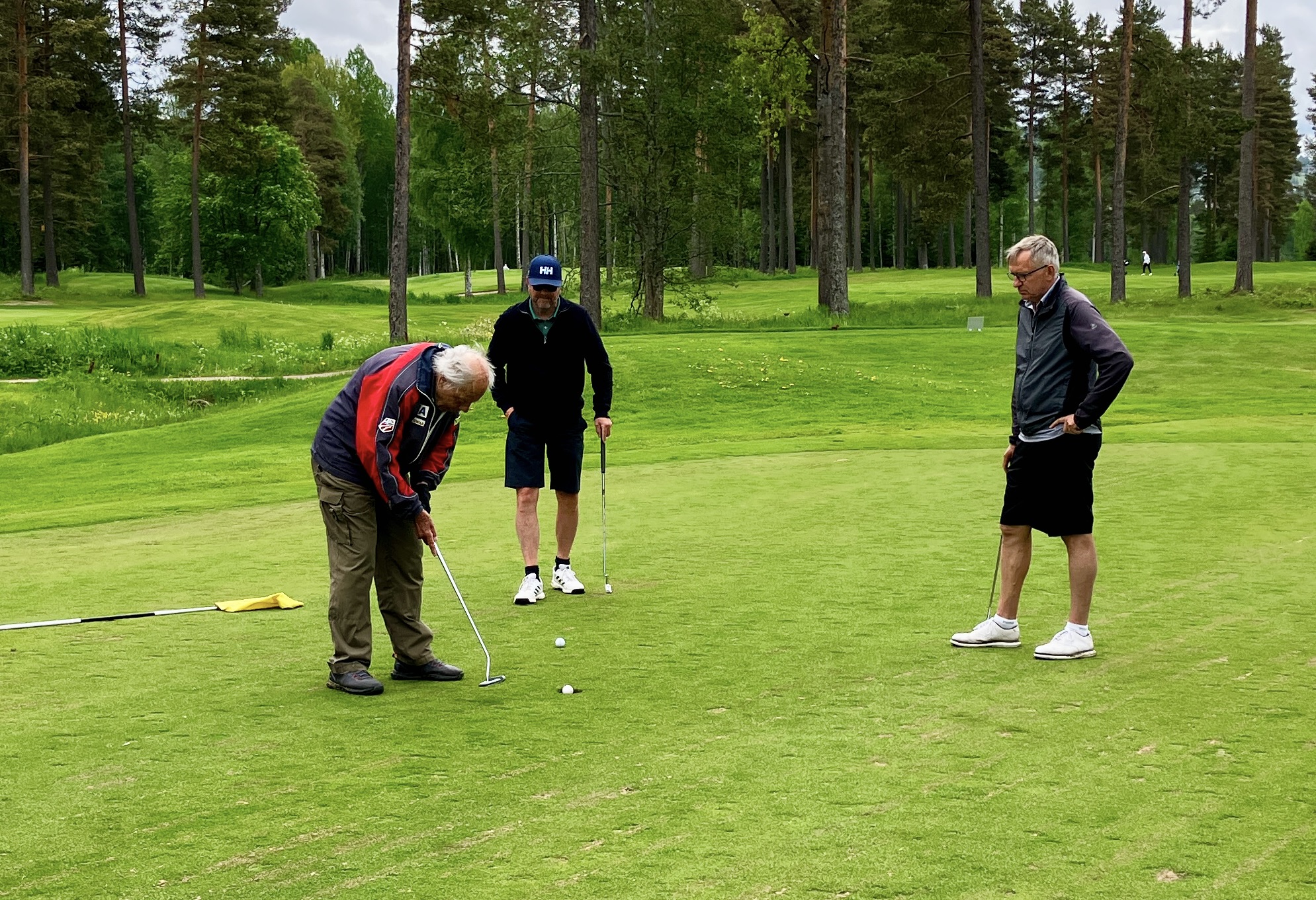 Åldermannen Lars Landstedt sänker en putt under överinseende av "ungdomarna" Bengt Dyrsmeds och Lasse Larsson.