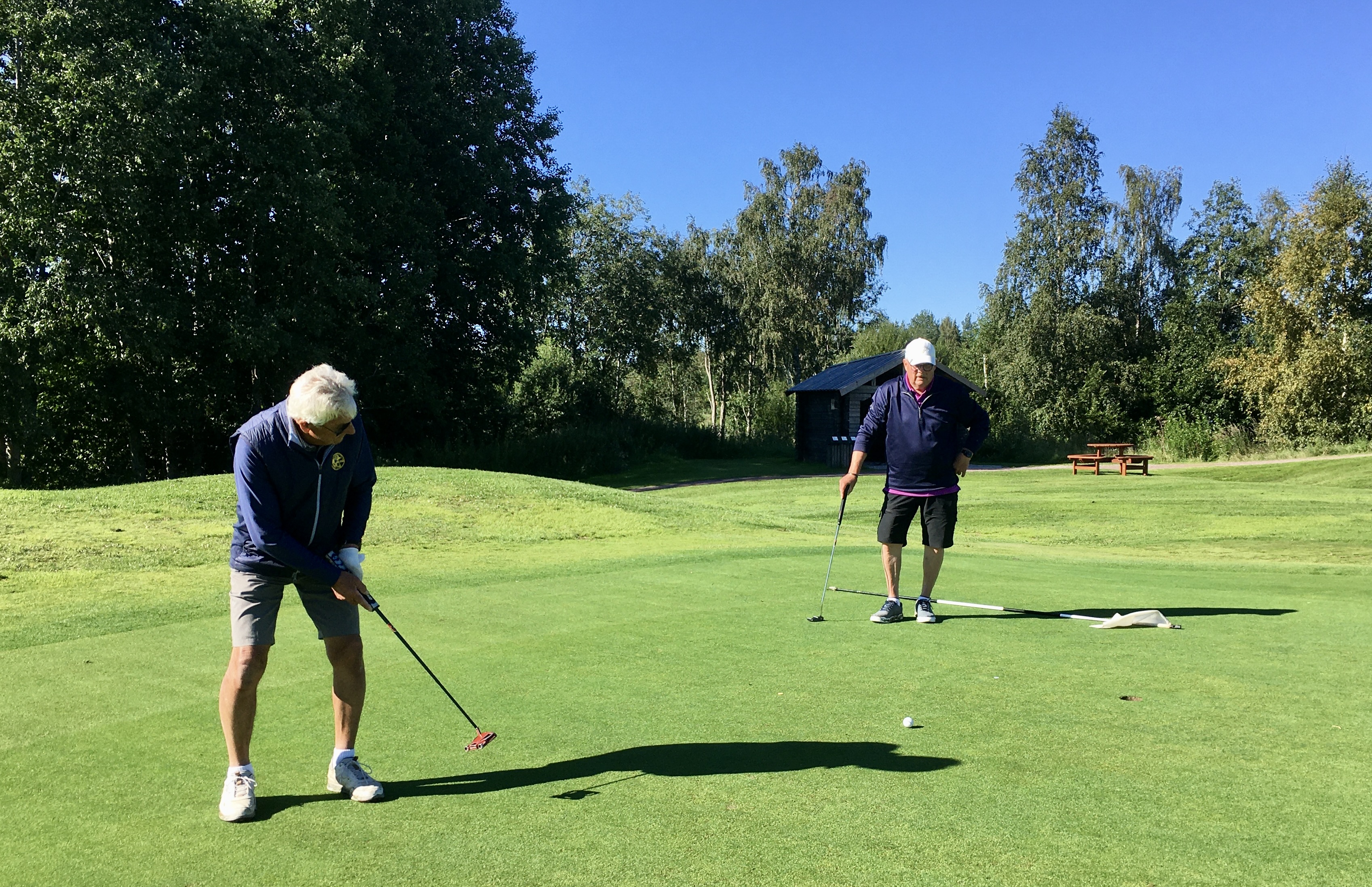 Lasse Hindriks puttar under överinseende av Åke Mårs på hål 8.