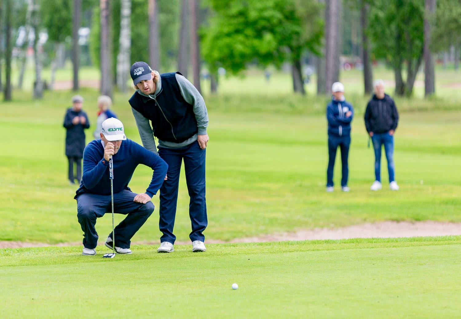 Magnus Ahlgren kollar puttlinjen med sonen William Nygård. FOTO: GÖRAN ERLANDSSON