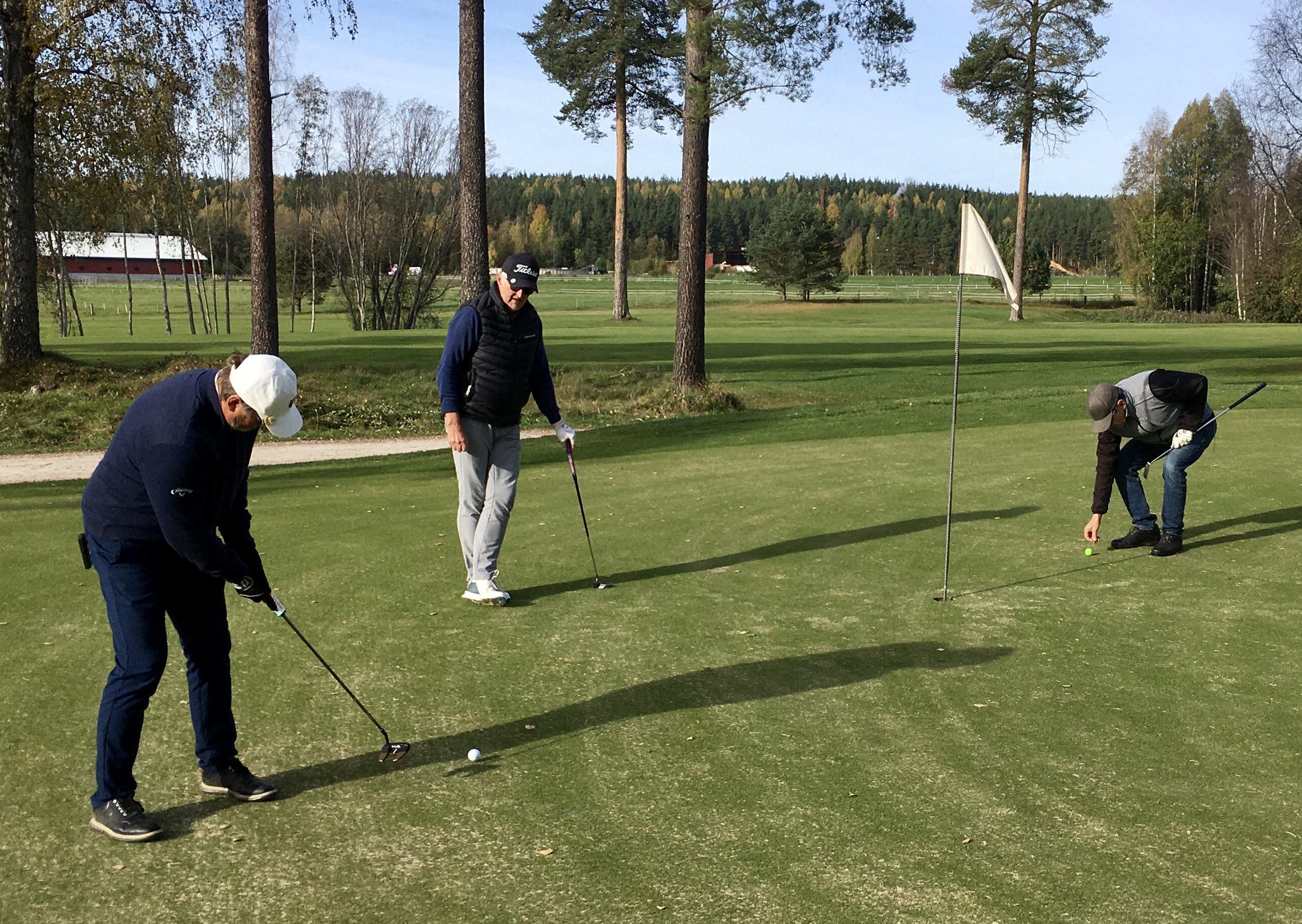 Sivert Andersson puttar på hål 11 medan Hans Jax tittar på och Johnny Norling gör nåt som han  inte bör göra.