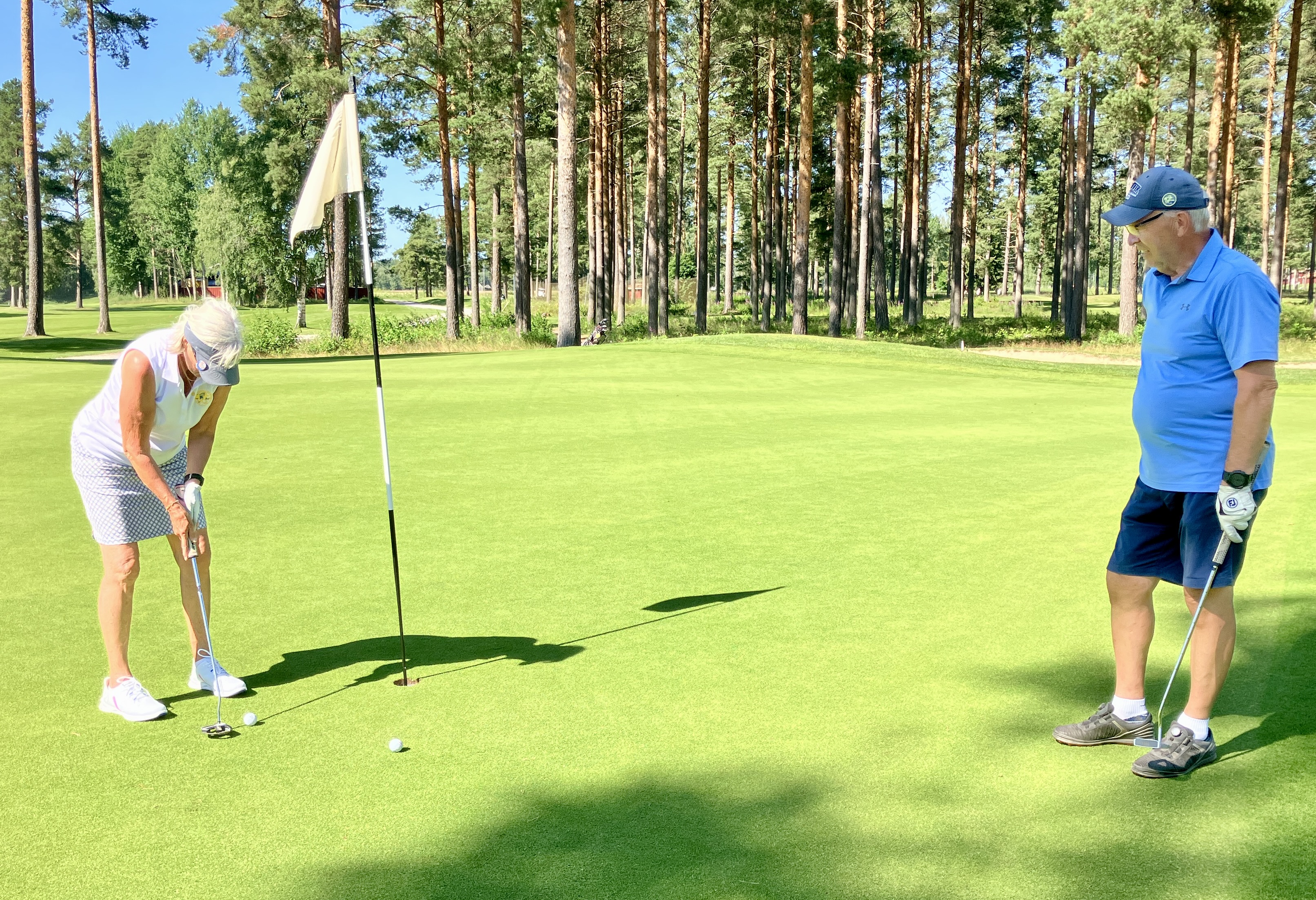 Lisa Kallur puttar i bollen på hål 11 och gör par under överinseende av Kenneth Sjöblom.